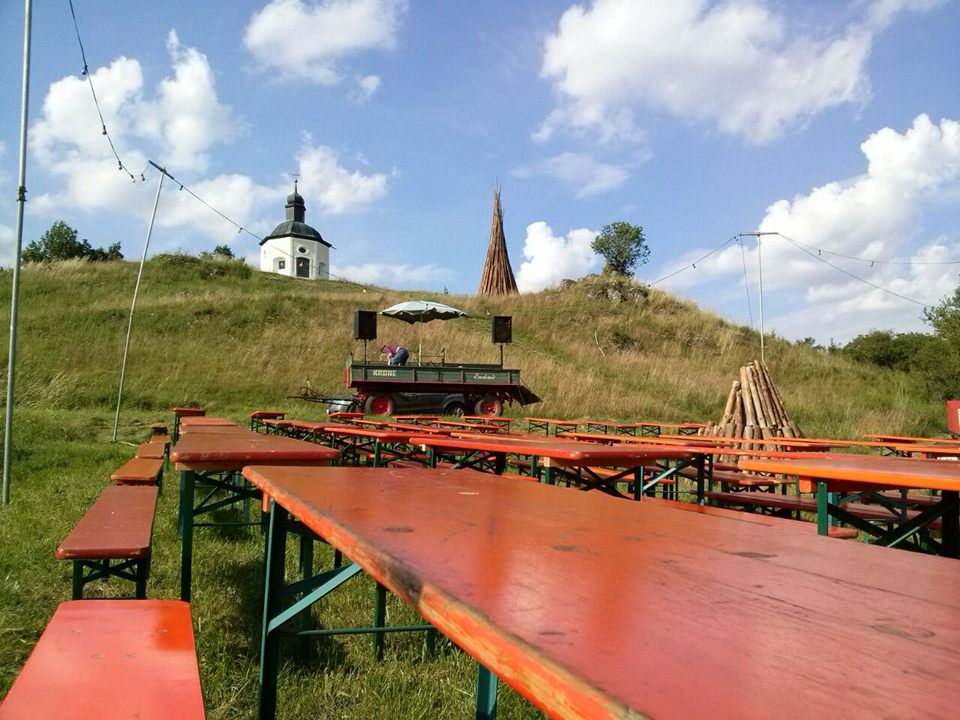 Bierbänke und Holzstoß für das Johannifeuer unter blauem Himmel