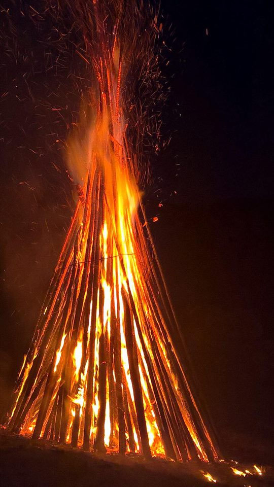 Lodernder Holzstoß des Johannifeuers bei Nacht mit Funkenflug